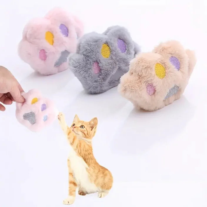 Cat paw-shaped toys with colorful paw prints on a white background, with a cat interacting with one of them.