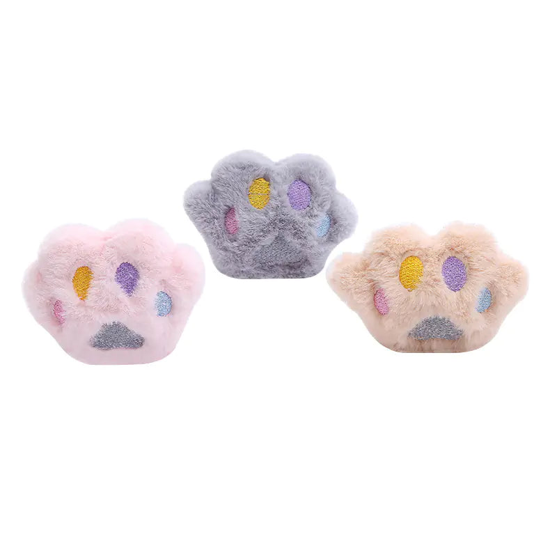 Three plush paw toys with colorful paw prints on a white background