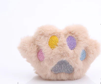 Plush toy shaped like a paw with colorful paw prints on a white background