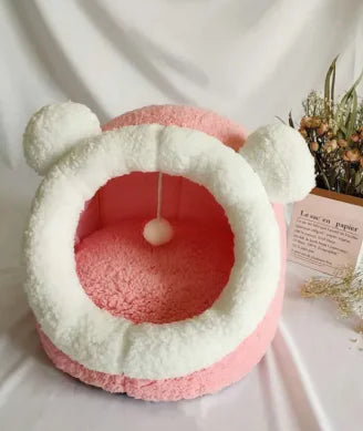 Pink and white pet bed with bear ears on a light background